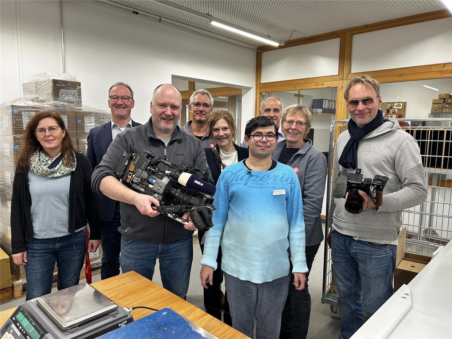 Gruppenfoto von Eric Seifert und allen Beteiligten bei den Dreharbeiten in den Caritas-Werkstätten.