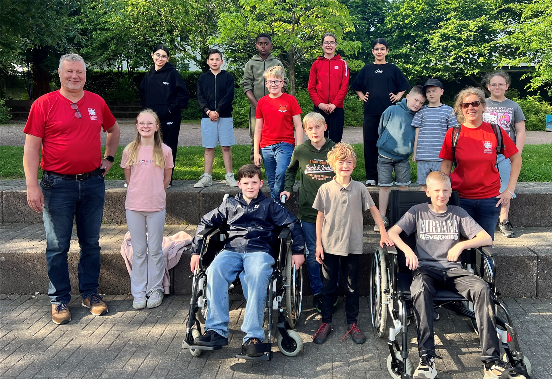Ralf Exner und Tanja Sprünker-Eraerds stehen mit den Schülern der Klasse 5d der Erich Kästner Realschule plus auf dme Schulhof zum Gruppenfoto zusammen.